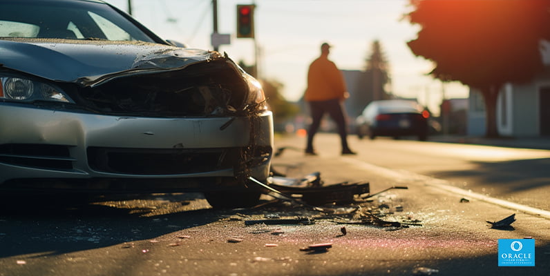 Dos coches implicados en un accidente automovilístico y una persona hablando con un agente de seguros