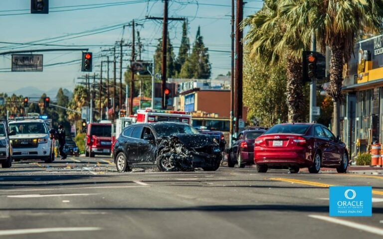 A realistic daytime photo of a serious car accident at a busy Anaheim intersection, involving multiple damaged vehicles, visible traffic lights, and nearby storefronts. Police officers are documenting the scene while emergency responders assist from the roadside. No visible injuries or graphic content. Clear Southern California lighting, urban Orange County
