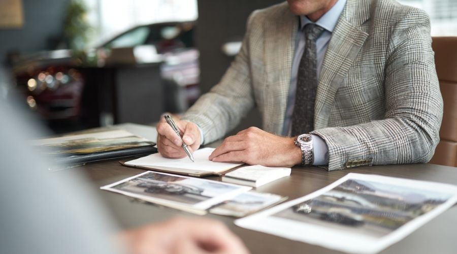 A professional, realistic image of a car accident attorney meeting with a client in a modern office, reviewing accident photos and documents together. 