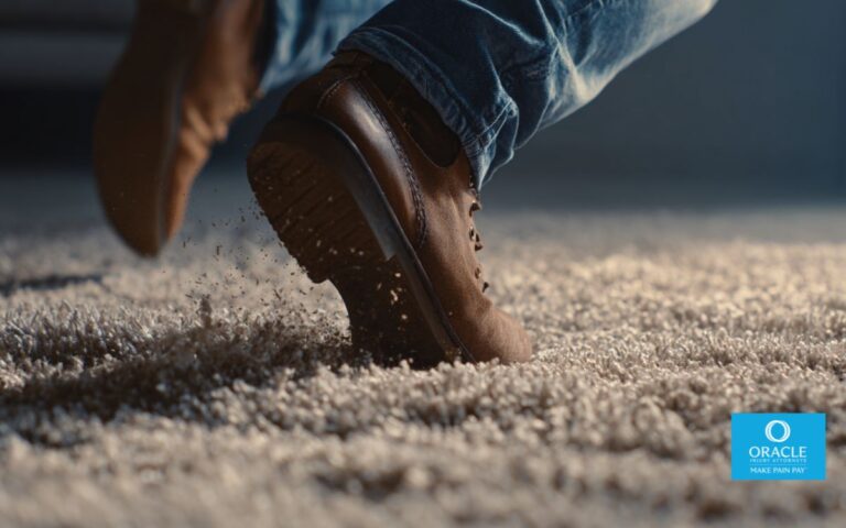 A close up to the feet of a person falling down caused by an uneven carpet