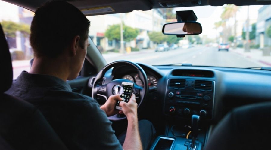 How Personal Injury Lawyers Prove Negligence in California (Effective Strategies That Win Cases) 1 A subtle conceptual image of a distracted driver looking at a phone while driving, slightly blurred motion, realistic urban California setting, symbolizing careless behavior