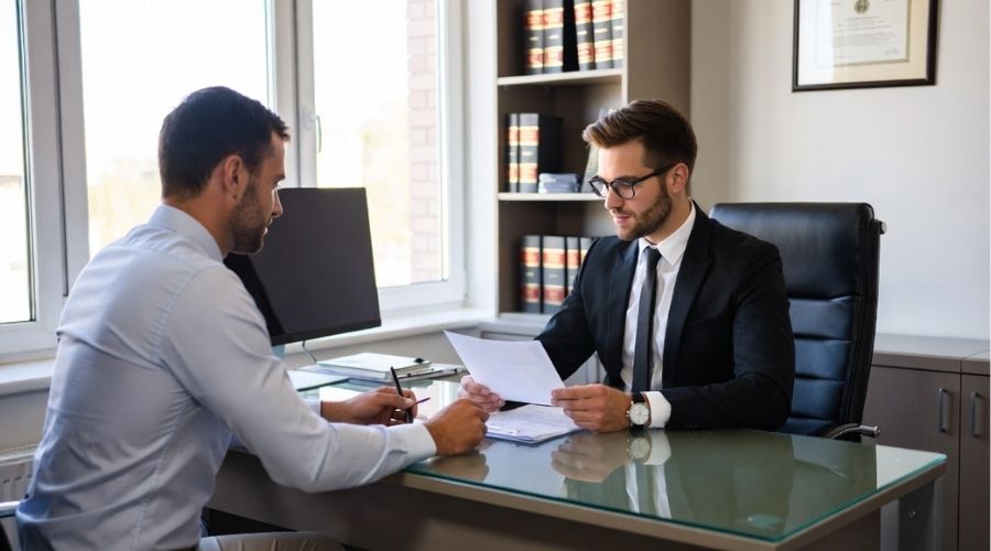 Compensación laboral en Anaheim: Lo que los empleados lesionados deben saber en 2026 4 Un abogado profesional se reúne con un cliente en un moderno despacho de abogados, revisando documentos juntos, ambiente seguro y tranquilizador, entorno de oficina limpio y elegante, iluminación natural, gran atención al detalle, 3:2