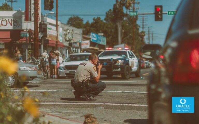 car accident scene in Costa Mesa intersection, police officer documenting incident, vehicles pulled over, daylight, realistic urban California setting, candid photojournalism style