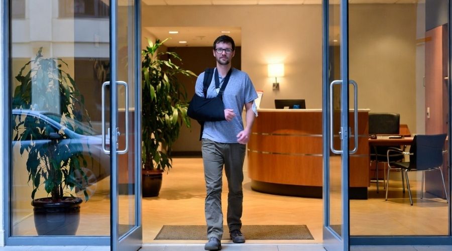 Costa Mesa Job Injury Claims: Can You Choose Your Own Doctor? 3 A confident injured worker walking into a law office reception area, hopeful expression, clean and modern interior, warm and inviting lighting, subtle sense of resolution
