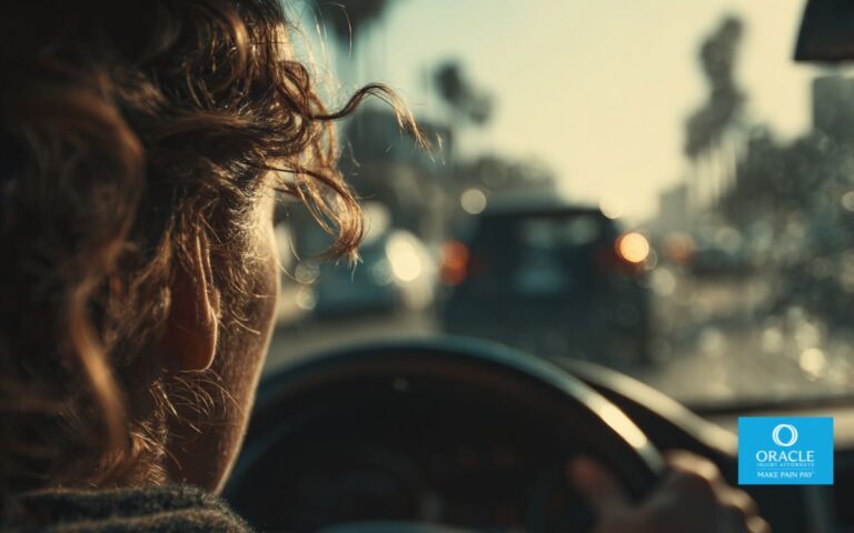 A close-up, over-the-shoulder view of a driver sitting inside a stopped car moments after a rear-end collision, hands gripping the steering wheel, slightly blurred damaged vehicle visible ahead through the windshield, natural daylight, shallow depth of field, realistic California street setting, emotional tension and uncertainty, clean and professional tone, no gore