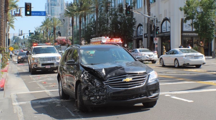 Santa Ana Auto Accidents: When Should You Hire a Personal Injury Attorney? 1 person sitting alone at desk late at night reviewing accident paperwork, dim desk lamp lighting, slightly stressed expression, realistic home office, subtle shadows, cinematic but natural