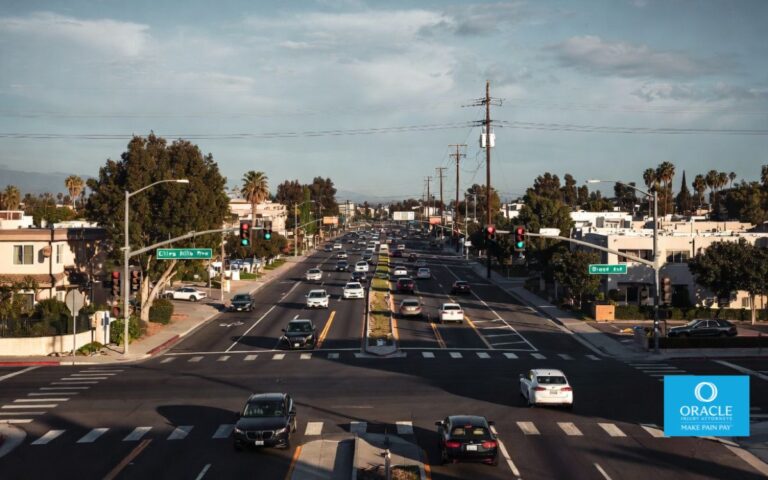 A busy suburban intersection in Chino Hills California at rush hour, multiple lanes of traffic, warm late afternoon lighting, cinematic wide angle editorial photography, no text