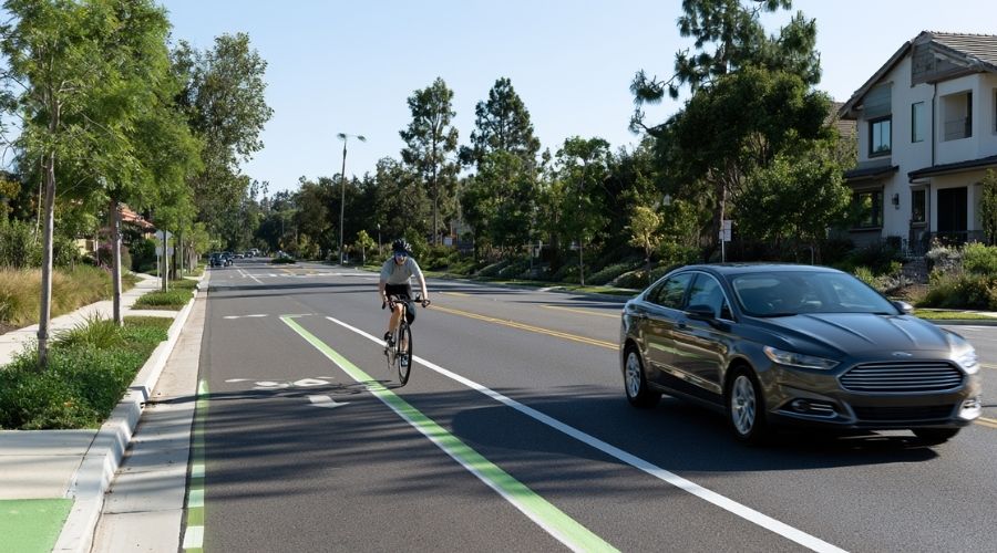 A realistic California roadway showing a motor vehicle safely passing a cyclist with a clearly visible three-foot buffer between them. Modern suburban street with bike lane, lane markings, and Orange County scenery. Educational, high-detail, photorealistic, natural daylight, no text, no logos.