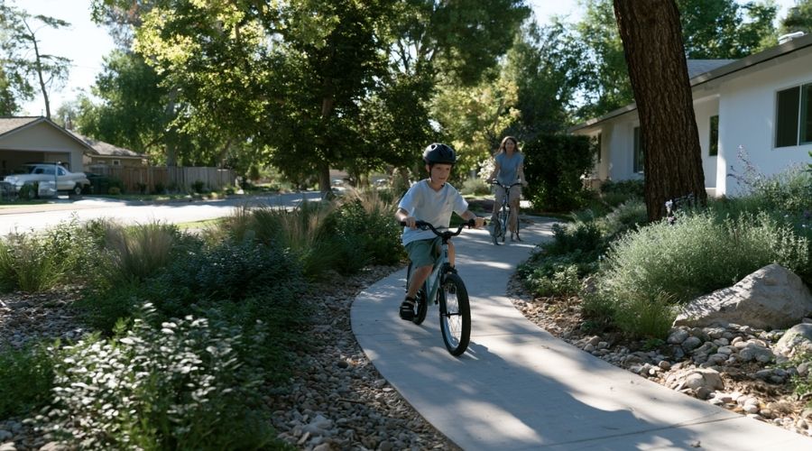 Understanding California Bicycle Helmet Laws for Riders of All Ages 1 Photorealistic child riding a bicycle while wearing a properly fitted safety helmet on a neighborhood bike path, parent riding alongside, safe family cycling environment, realistic California suburban setting, highly detailed, 8k