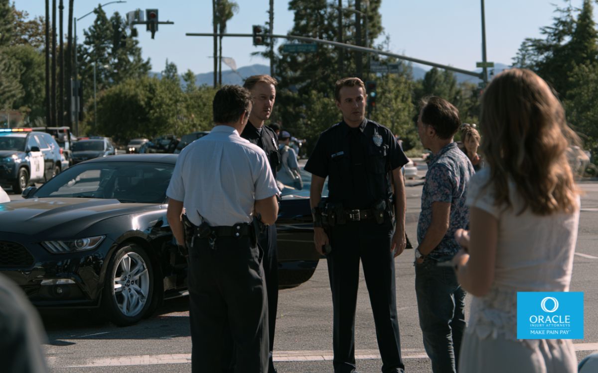 Photorealistic car accident at a busy California intersection, independent witnesses speaking with police officers while injured parties receive assistance, realistic traffic conditions, documentary-style photography, cinematic lighting, ultra-detailed