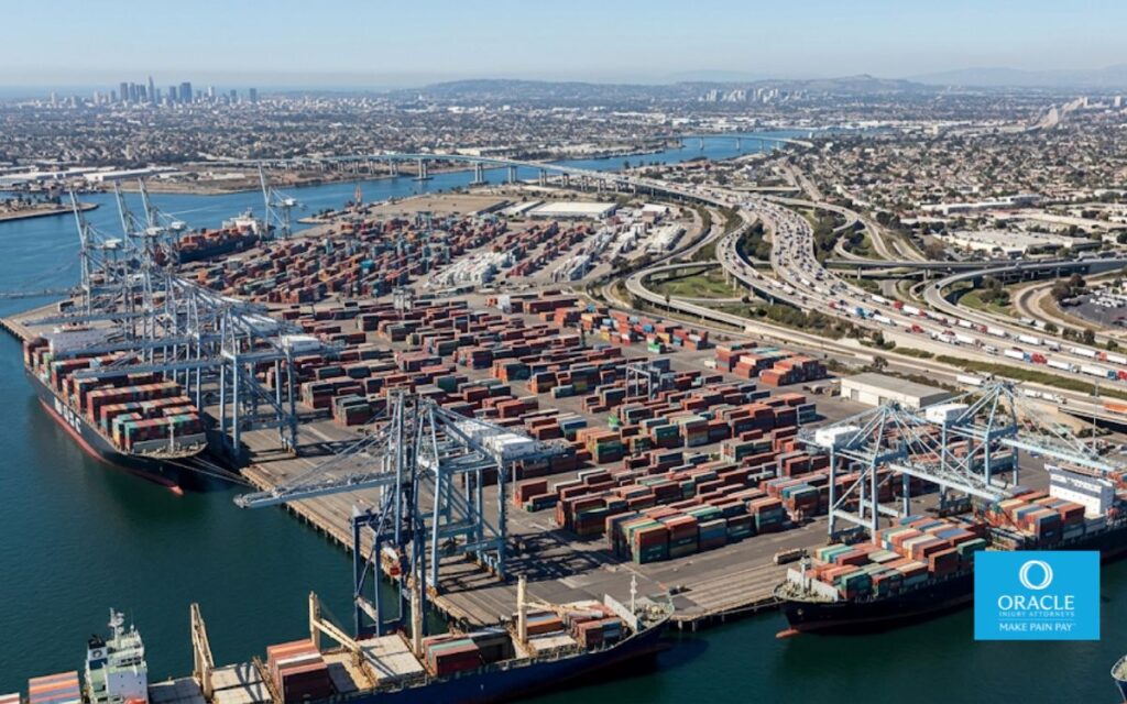 An aerial wide shot of the Port of Long Beach showing container cranes, stacked shipping containers, and the 710 Freeway visible in the background, daylight. No accident depicted. Represents the scale of the port and its freeway corridor.