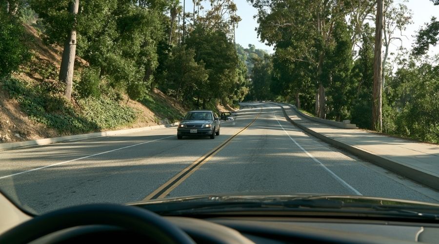 Pasadena Car Accident Attorney: Navigating a Claim in LA County 2 A driver's point-of-view shot on the Arroyo Seco Parkway
showing the narrow lanes, curved alignment, and tree-lined
shoulders typical of this historic freeway, daylight. No
accident depicted, no faces visible. Represents the
pre-modern design characteristics that make the 110
uniquely dangerous.