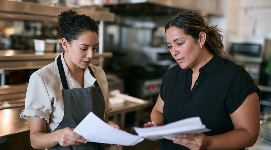 Un empleado de un restaurante comenta con su supervisor una lesión sufrida en el trabajo.
