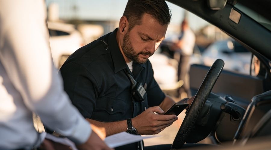 Person photographing vehicle damage to document evidence after a California car accident.